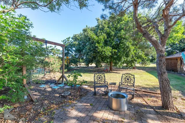 a view of a chair and table in the backyard