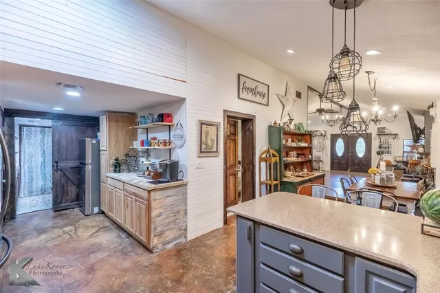 a kitchen with stainless steel appliances kitchen island granite countertop a stove and cabinets