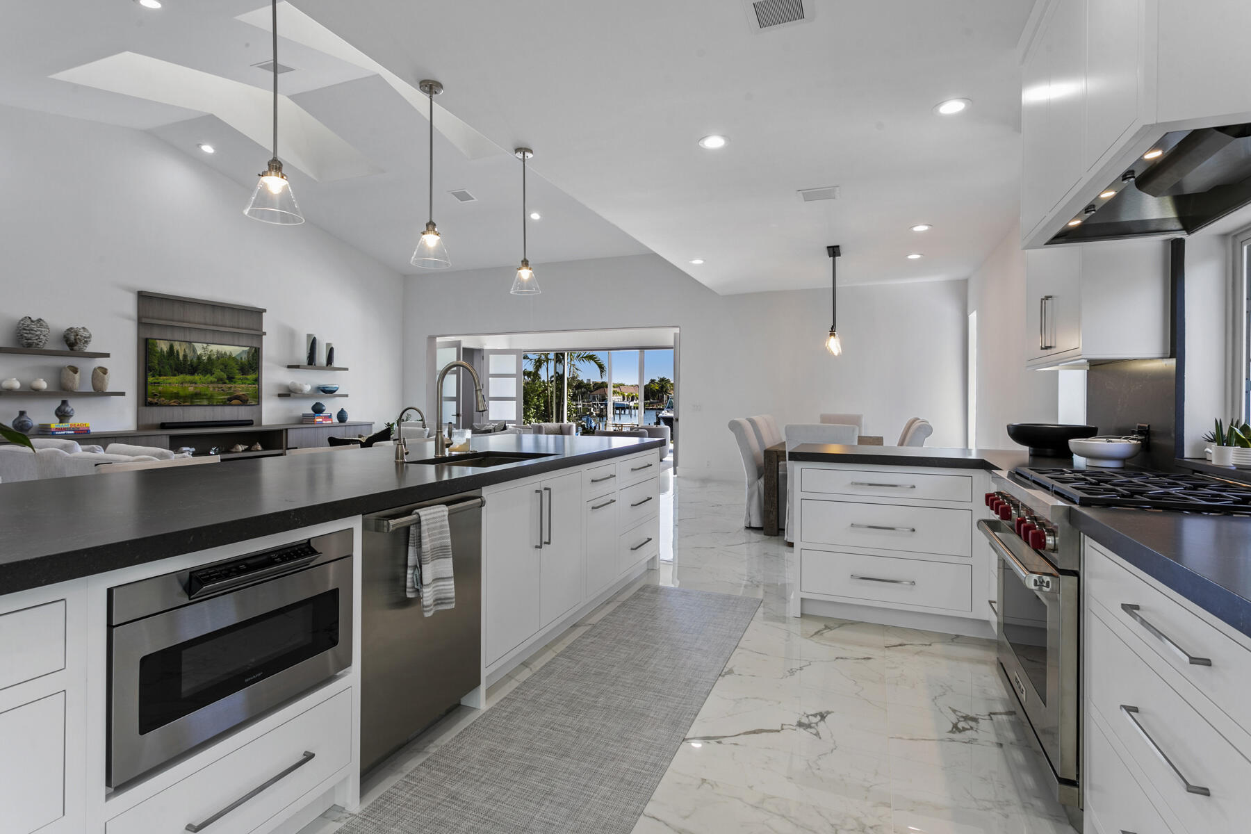 245 Regatta Drive Jupiter, FL 33477 - Photo 14 of 51 a large kitchen with stainless steel appliances kitchen island granite countertop a stove and a sink