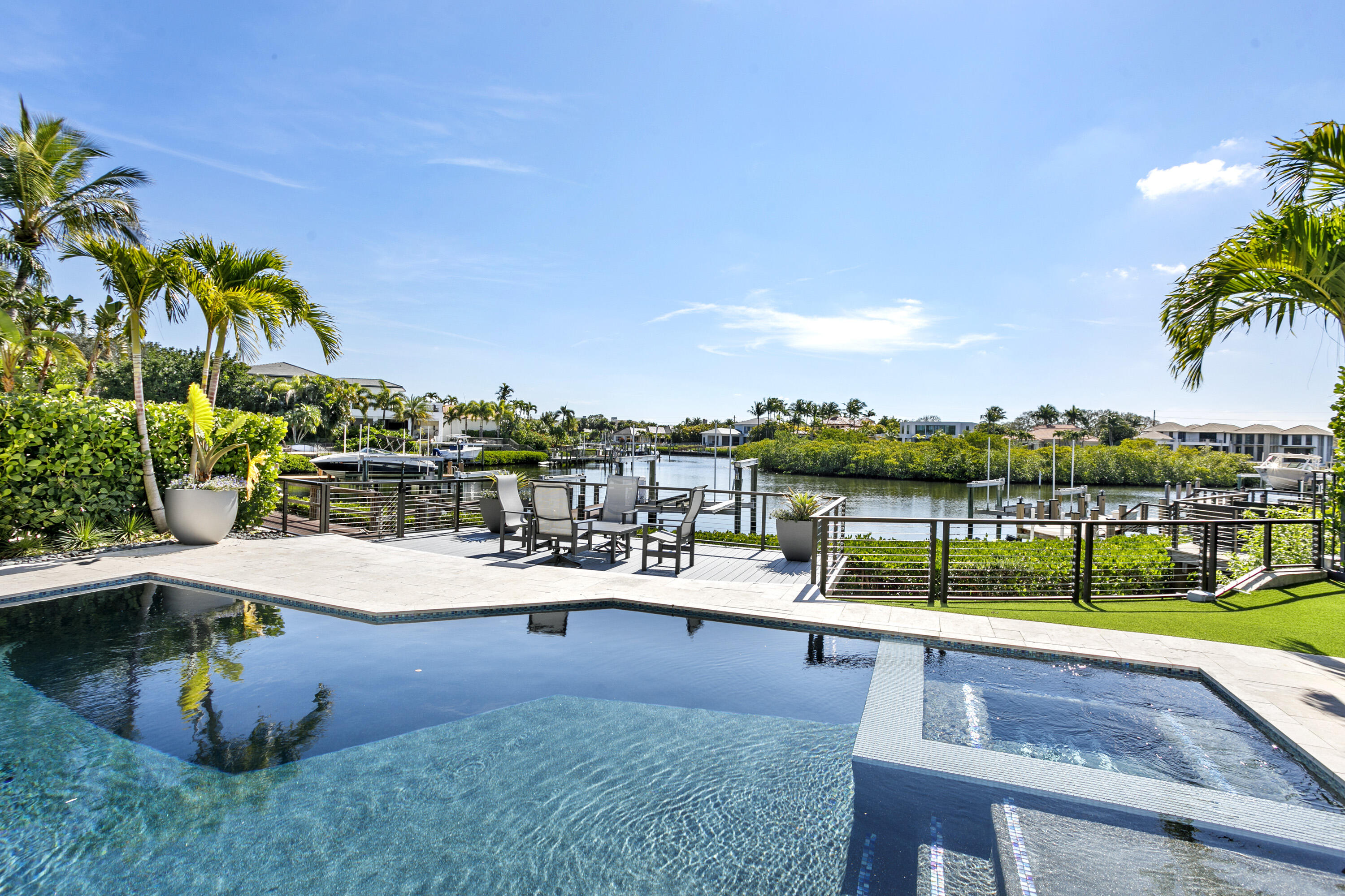 245 Regatta Drive Jupiter, FL 33477 - Photo 34 of 51 a view of a swimming pool with a lawn chairs under an umbrella