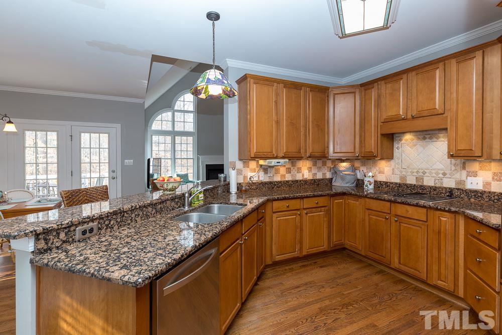 2921 Sunnystone Way Raleigh, NC 27613 - Photo 9 of 25 a kitchen with stainless steel appliances granite countertop sink stove and cabinets