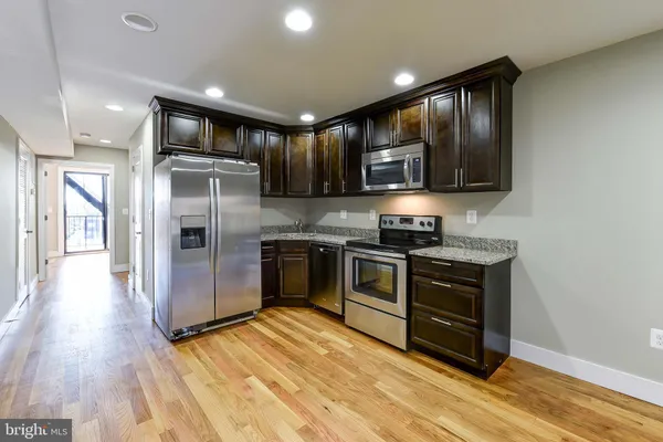 a kitchen with stainless steel appliances granite countertop a stove a refrigerator and a microwave