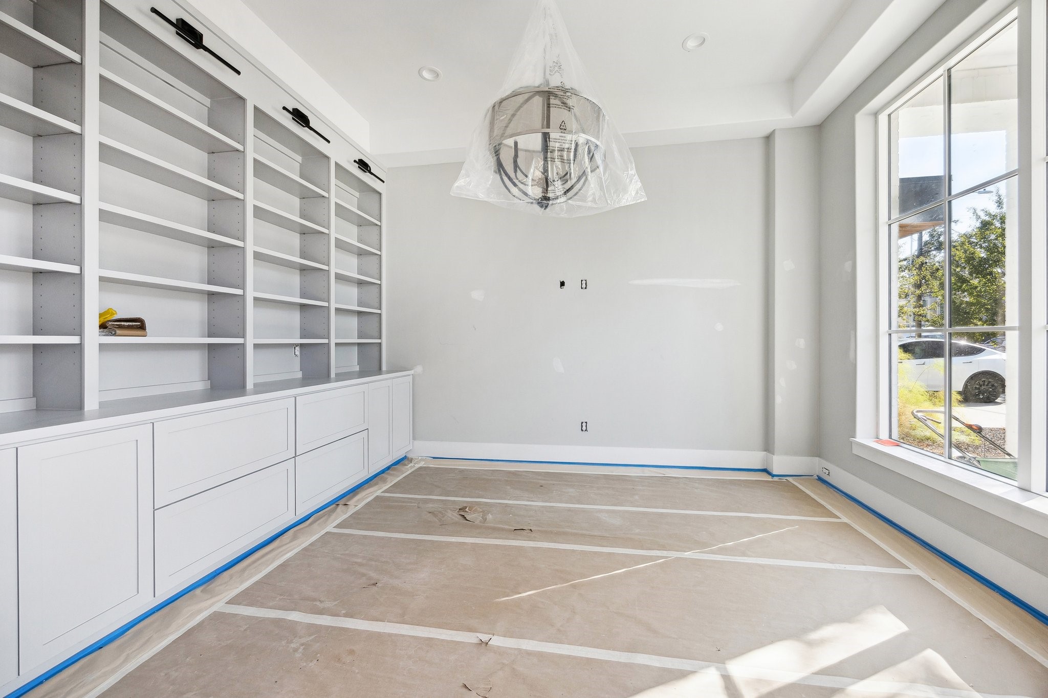 1118 Jackson Boulevard Houston, TX 77006 - Photo 2 of 19 Study off the entrance of the home with beautiful paneled walls, built-in shelving, cabinets and drawers. There is also a Modern Pedent Light and a Set of Divided Lite Doors.