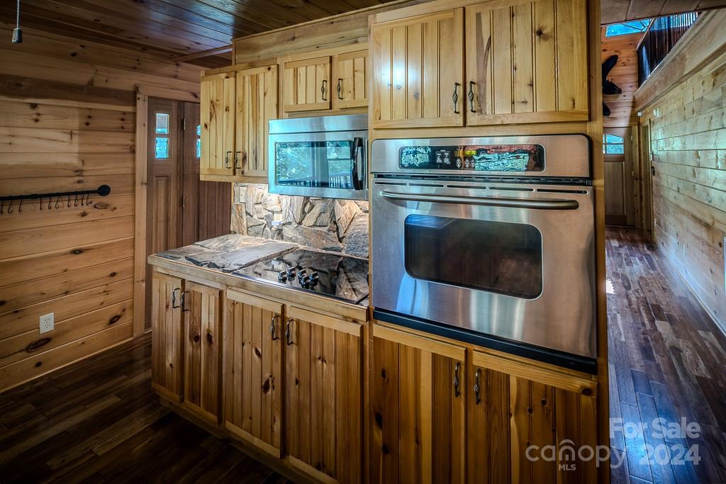 3346 Clarks Chapel Road Lenoir, NC 28645 - Photo 19 of 48 a kitchen with granite countertop a stove and a wooden cabinets