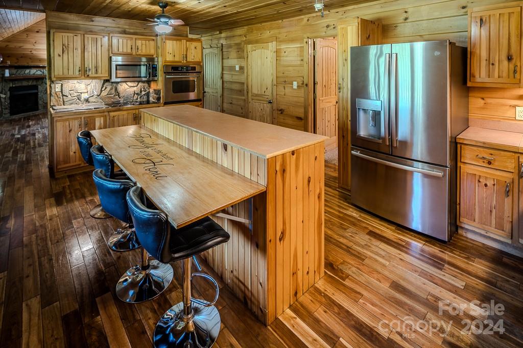 3346 Clarks Chapel Road Lenoir, NC 28645 - Photo 20 of 48 a kitchen with stainless steel appliances granite countertop a refrigerator a stove and white cabinets with wooden floor