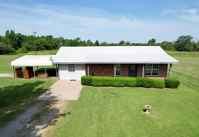 a aerial view of a house with a yard table and chairs