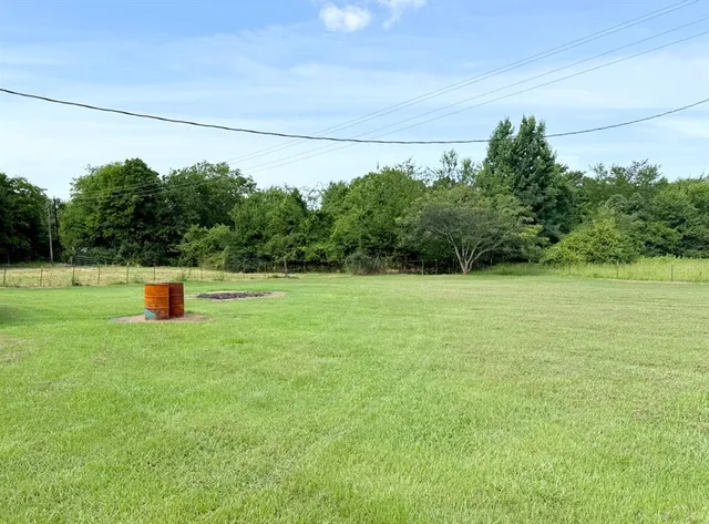 a backyard of a house with lots of green space and trees in the back