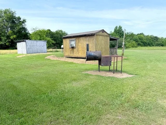 a view of a house with a yard and sitting area