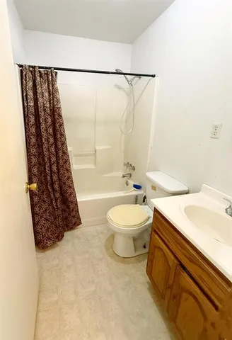 an empty room with a window and a ceiling fan