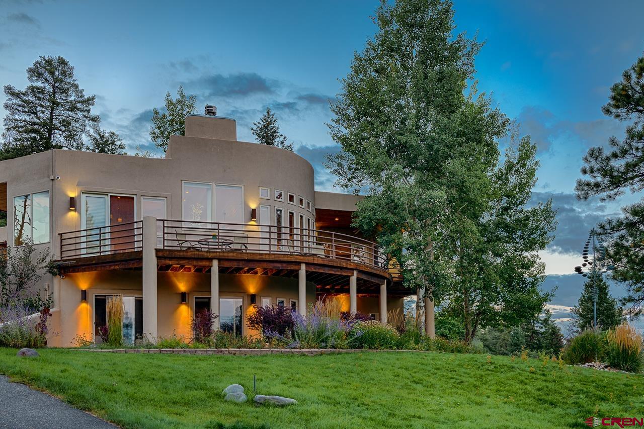 994 Cool Pines Drive Pagosa Springs, CO 81147 - Photo 1 of 35 a view of a white house with a big yard and potted plants