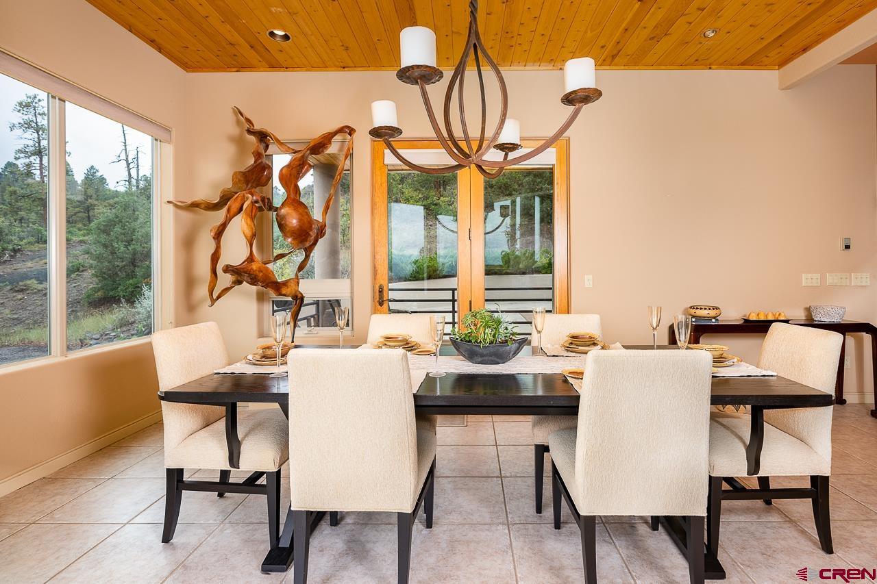 994 Cool Pines Drive Pagosa Springs, CO 81147 - Photo 12 of 35 a dining room with furniture a rug and a floor to ceiling window