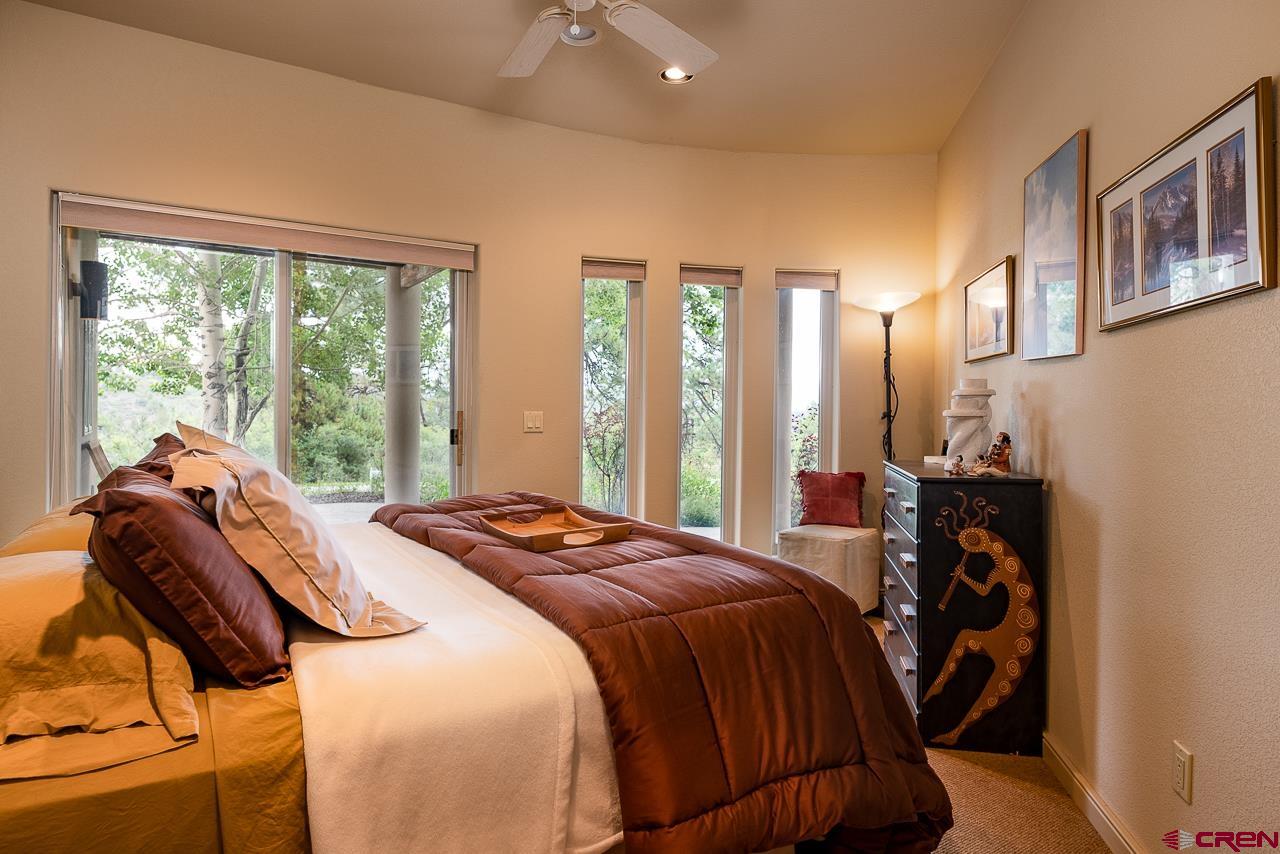 994 Cool Pines Drive Pagosa Springs, CO 81147 - Photo 29 of 35 a bedroom with a bed and large windows