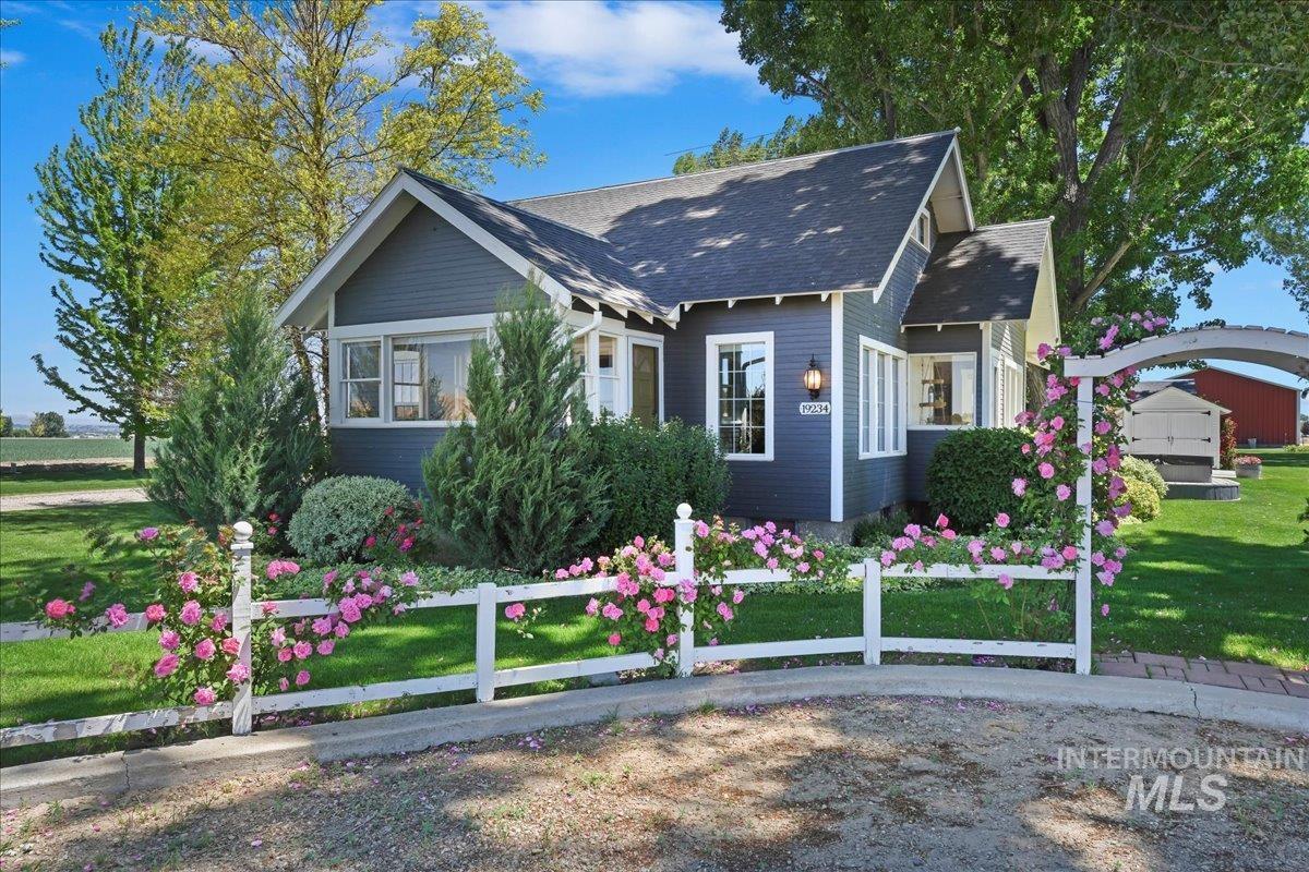 View of front facade featuring a front lawn and roof with shingles