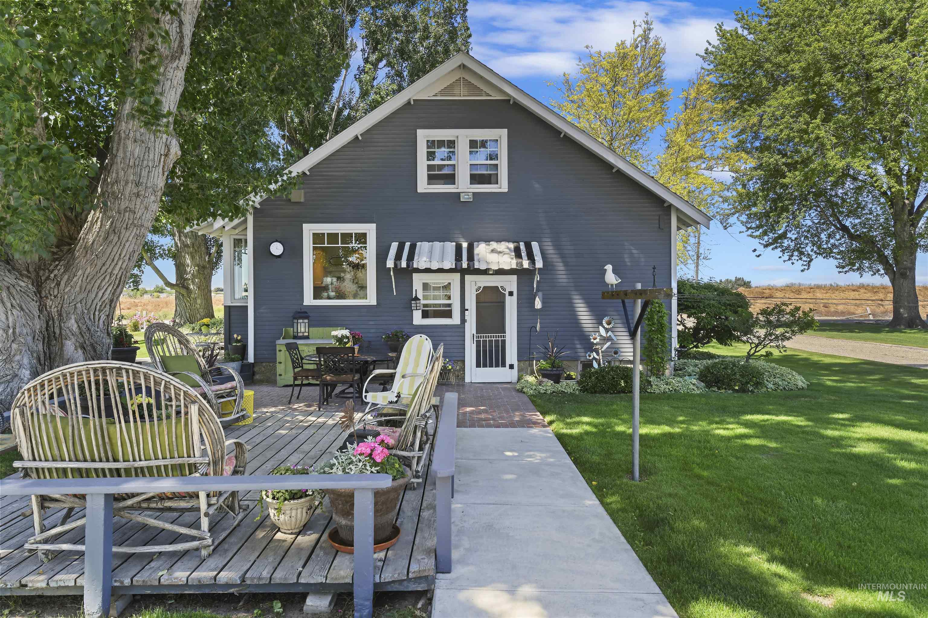 19234 Top Road Caldwell, ID 83607 - Photo 20 of 50 Rear view of property featuring a yard, a wooden deck, and outdoor dining area