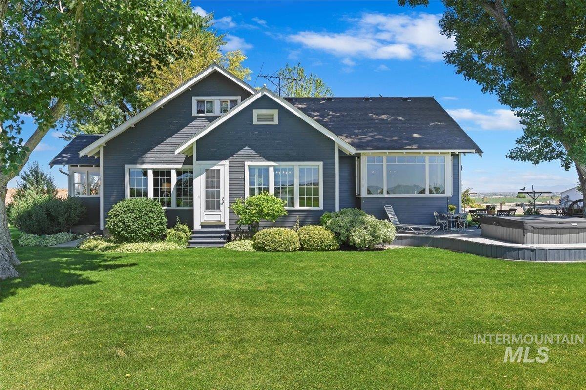 19234 Top Road Caldwell, ID 83607 - Photo 4 of 50 Side view of property featuring a lawn, entry steps, an outdoor hot tub, and a patio area