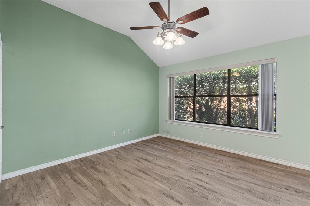 6905 Rochelle Drive Plano, TX 75023 - Photo 11 of 23 an empty room with wooden floor chandelier fan and windows