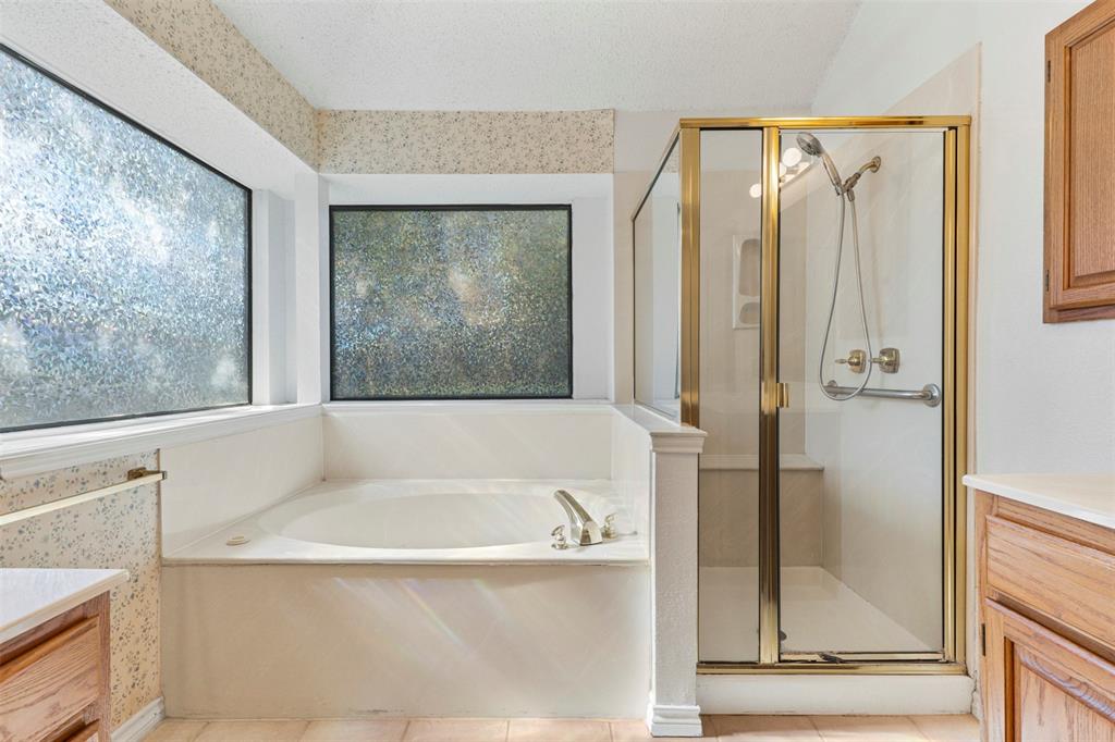 6905 Rochelle Drive Plano, TX 75023 - Photo 14 of 23 a bathroom with a bathtub and a shower