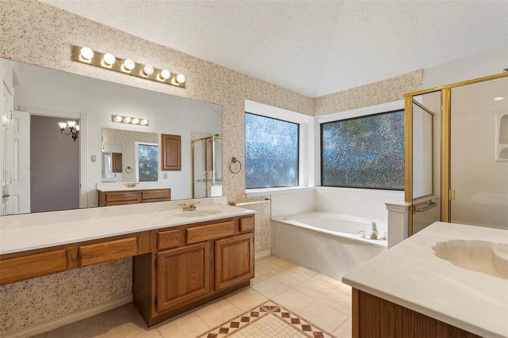6905 Rochelle Drive Plano, TX 75023 - Photo 15 of 23 a spacious bathroom with a granite countertop tub a double vanity sink and a large mirror