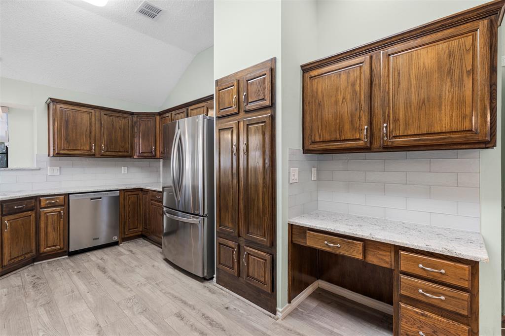6905 Rochelle Drive Plano, TX 75023 - Photo 9 of 23 a kitchen with granite countertop wooden cabinets stainless steel appliances and a window