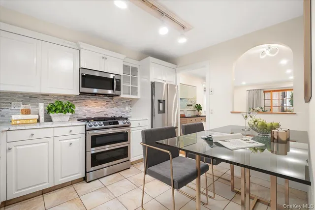 a kitchen with stainless steel appliances a stove a sink a microwave a refrigerator and cabinets