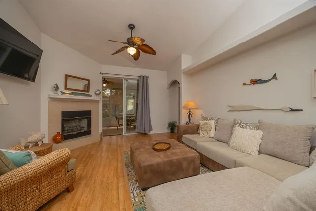 a living room with furniture a fireplace and a flat screen tv