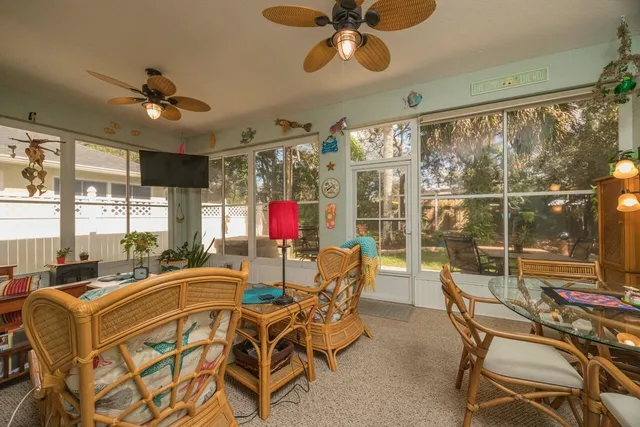 a dining room with furniture and a floor to ceiling window