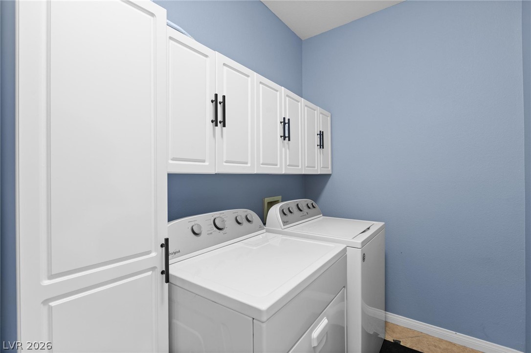 3238 Mystic Ridge Court Las Vegas, NV 89129 - Photo 17 of 31 Ample white cabinetry and appliances organize a functional laundry space.