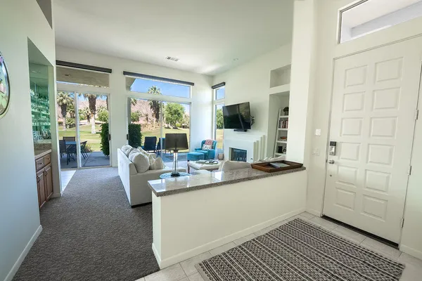 a living room with furniture a large window and a flat screen tv