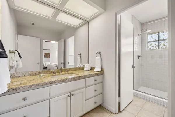 a bathroom with a granite countertop sink and a mirror