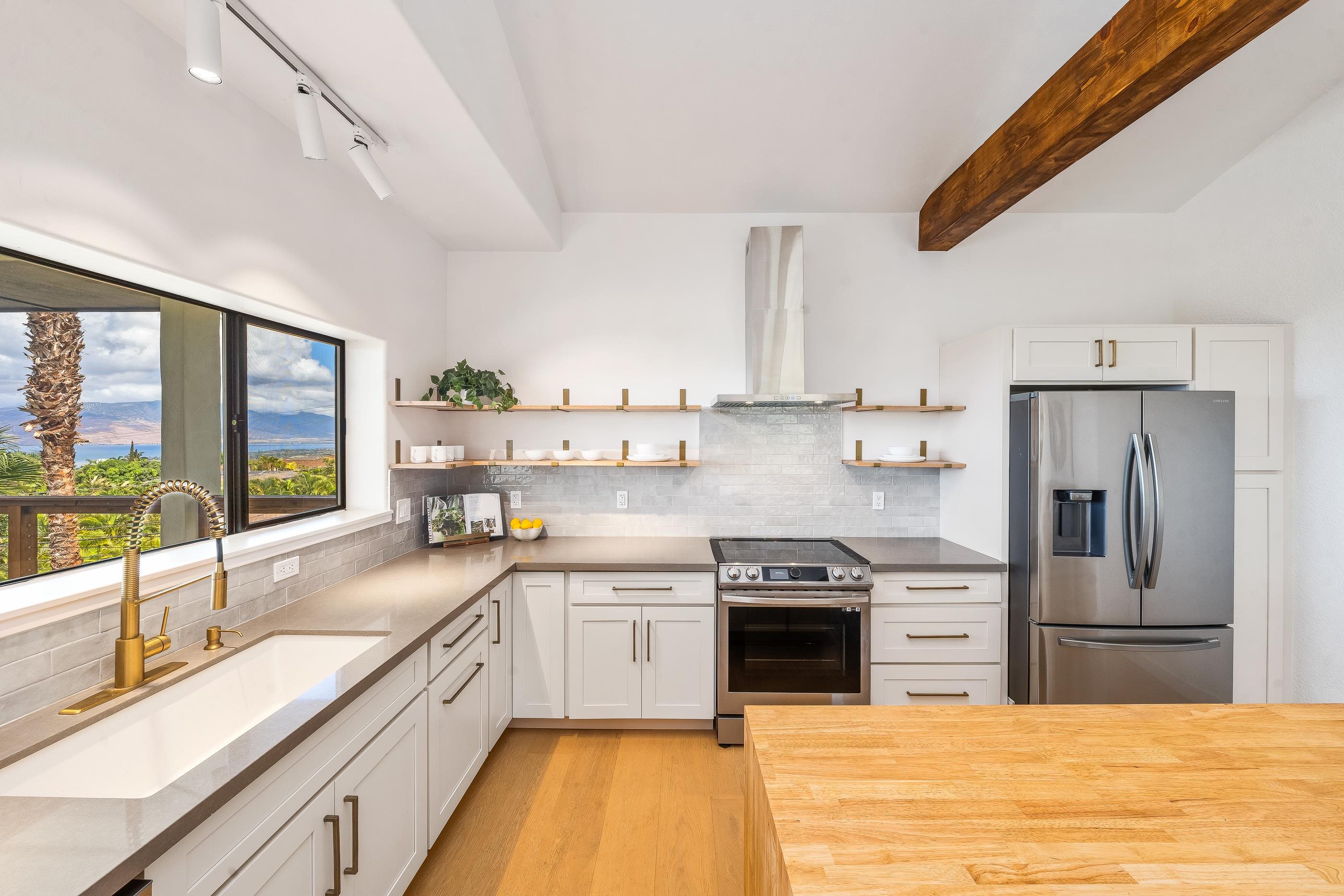 820 Kupulau Drive Kihei, HI 96753 - Photo 11 of 50 a kitchen with stainless steel appliances granite countertop a stove a sink and a refrigerator