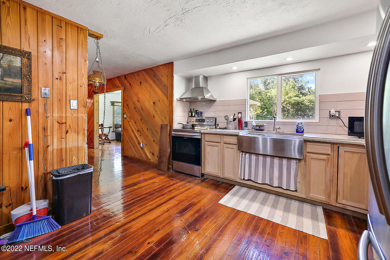 574 Clifton Road Crescent City, FL 32112 - Photo 15 of 38 a open kitchen with stainless steel appliances granite countertop a stove top oven a sink dishwasher and wooden cabinets with wooden floor