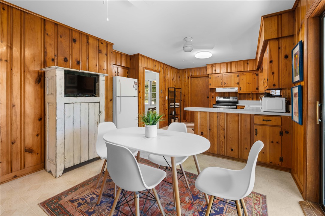 207 Brook Street Clemson, SC 29631 - Photo 13 of 39 A cozy, wood-paneled eat-in kitchen area awaits with modern white appliances and a casual dining setup.