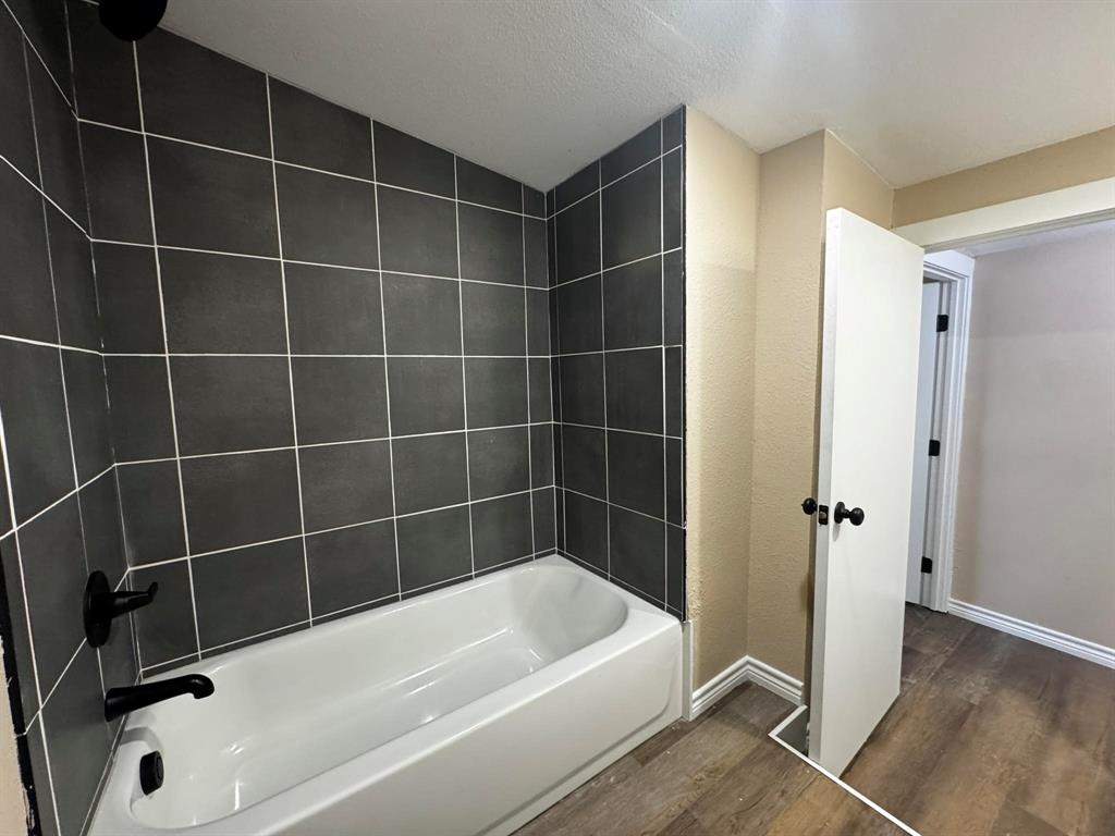 210 Reta Street Stephenville, TX 76401 - Photo 11 of 13 a bathroom with a bathtub