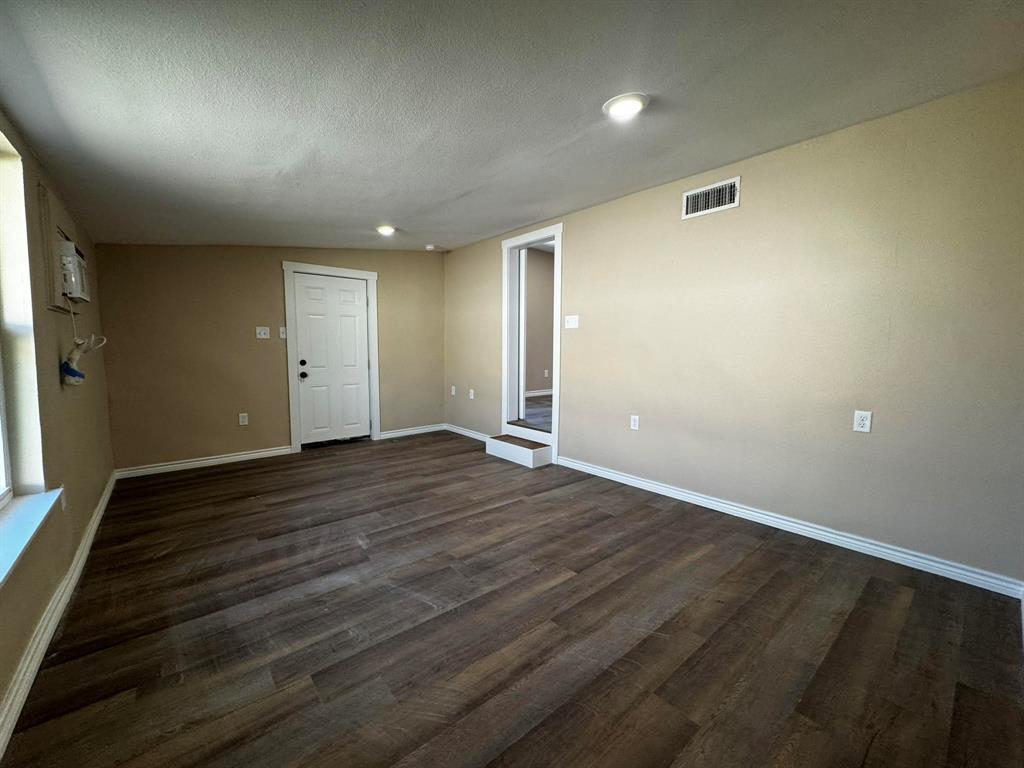 210 Reta Street Stephenville, TX 76401 - Photo 12 of 13 an empty room with wooden floor and windows