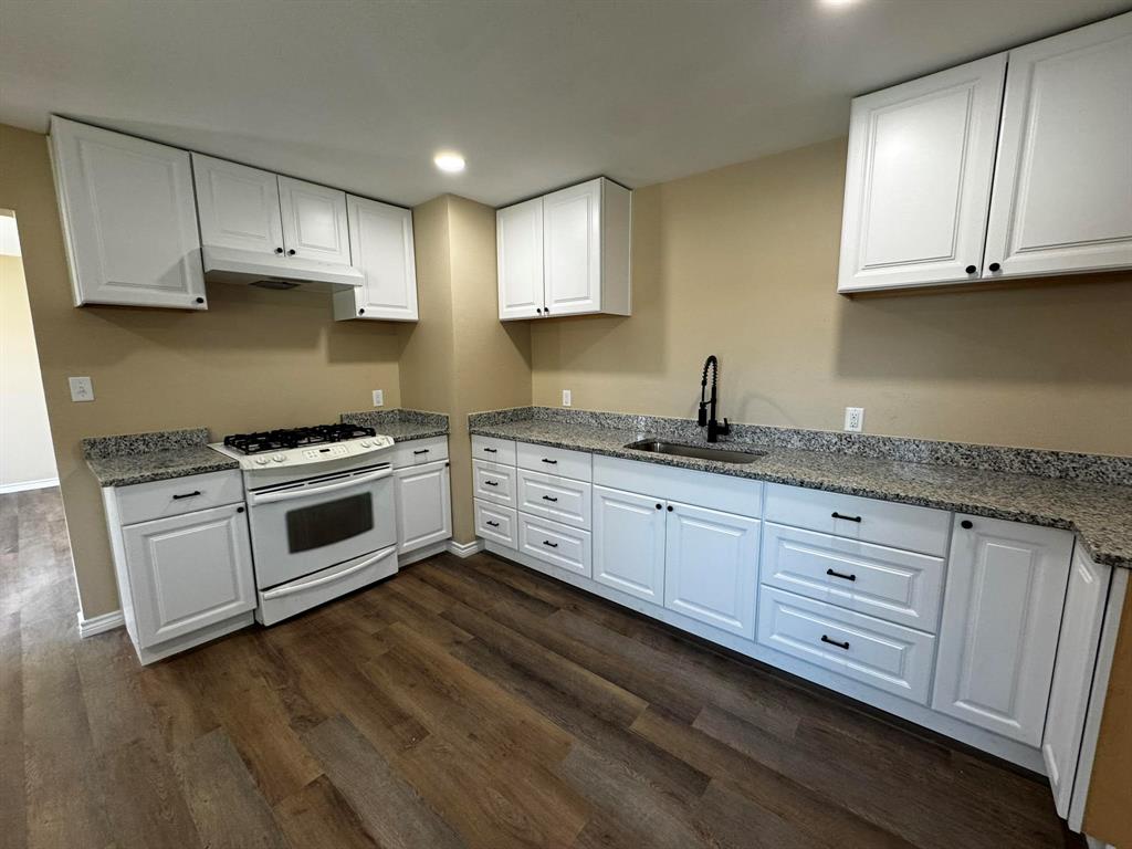 210 Reta Street Stephenville, TX 76401 - Photo 13 of 13 a kitchen with granite countertop white cabinets and white appliances