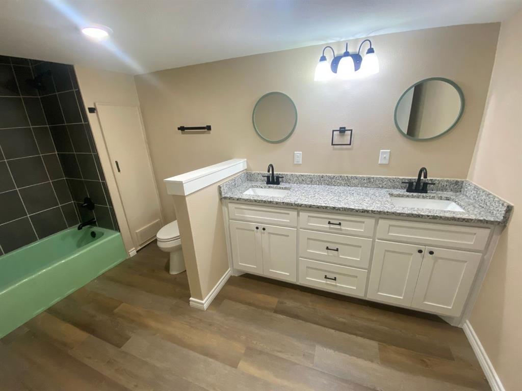 210 Reta Street Stephenville, TX 76401 - Photo 3 of 13 a spacious bathroom with a granite countertop sink a mirror and a