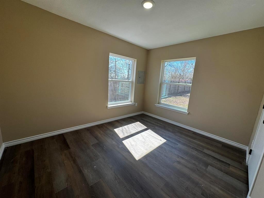 210 Reta Street Stephenville, TX 76401 - Photo 5 of 13 a view of an empty room with wooden floor and a window
