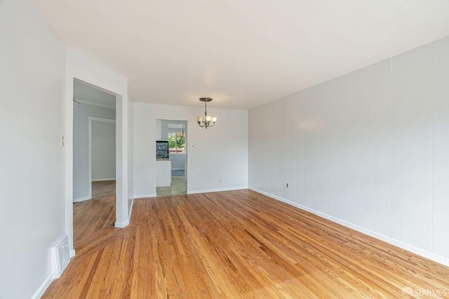 a view of a big room with wooden floor and a bathroom