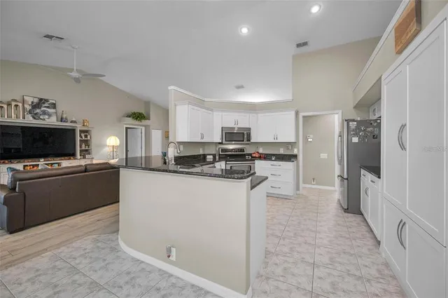 a kitchen with kitchen island granite countertop wooden cabinets and a granite counter tops