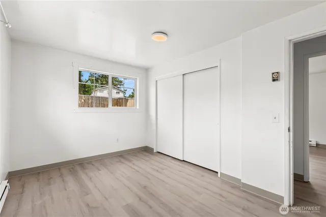 an empty room with wooden floor and window