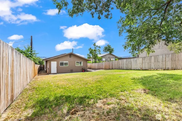 a large house with a big yard plants and large trees