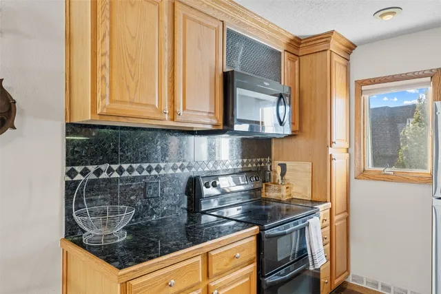 a kitchen with granite countertop a stove and a sink