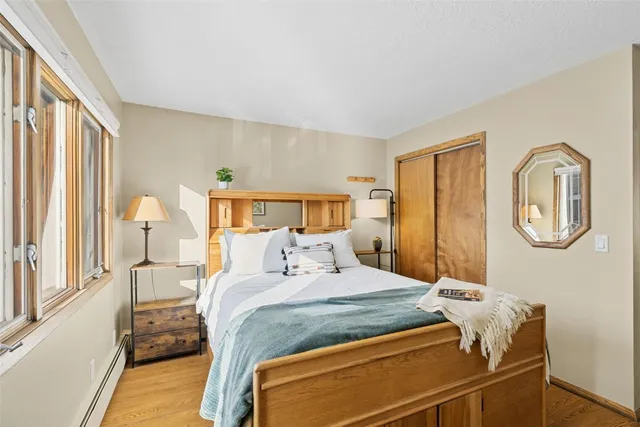 a bedroom with a bed and wooden floor