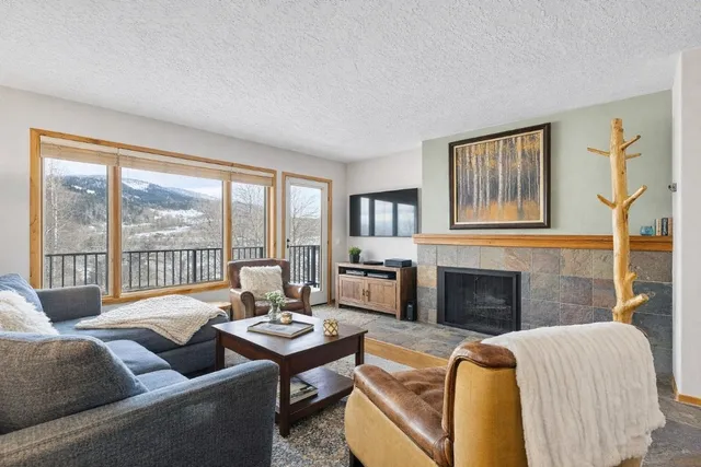 a living room with furniture large window and a fireplace