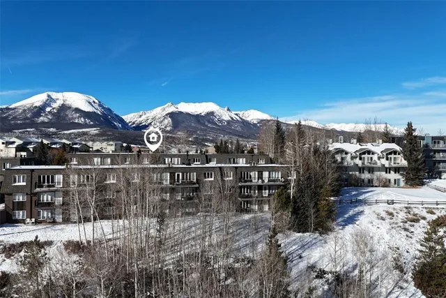 a view of a house with a yard and mountain view in back