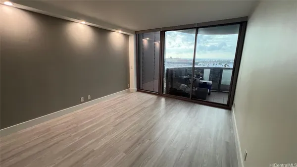 an empty room with wooden floor and windows