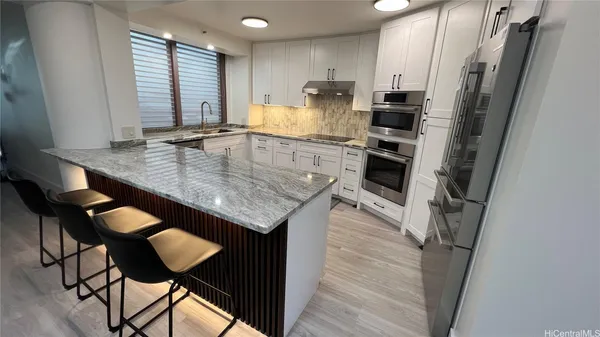 a kitchen with stainless steel appliances granite countertop a sink a stove a refrigerator and island
