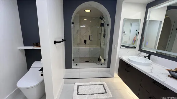 a bathroom with a sink a toilet and shower