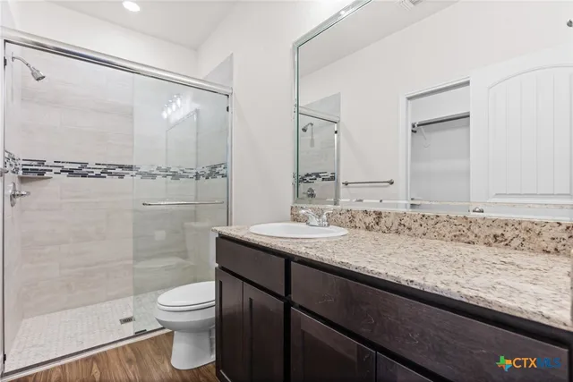 a bathroom with a granite countertop sink toilet and shower
