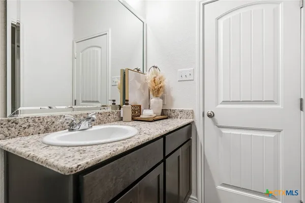 a bathroom with a granite countertop sink and a mirror